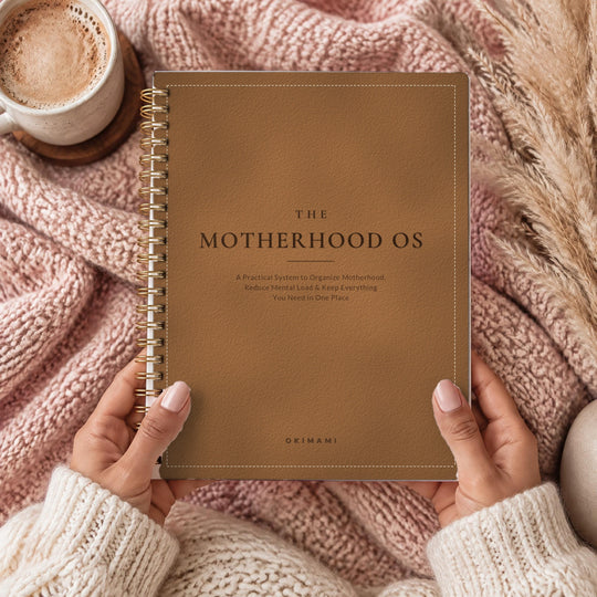 The Motherhood OS, held in hands